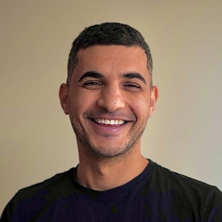 Portrait of Feras Shamasna smiling, wearing a black t-shirt